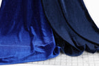 a close-up view of a blue fabric with a glittery texture, placed on a white surface.