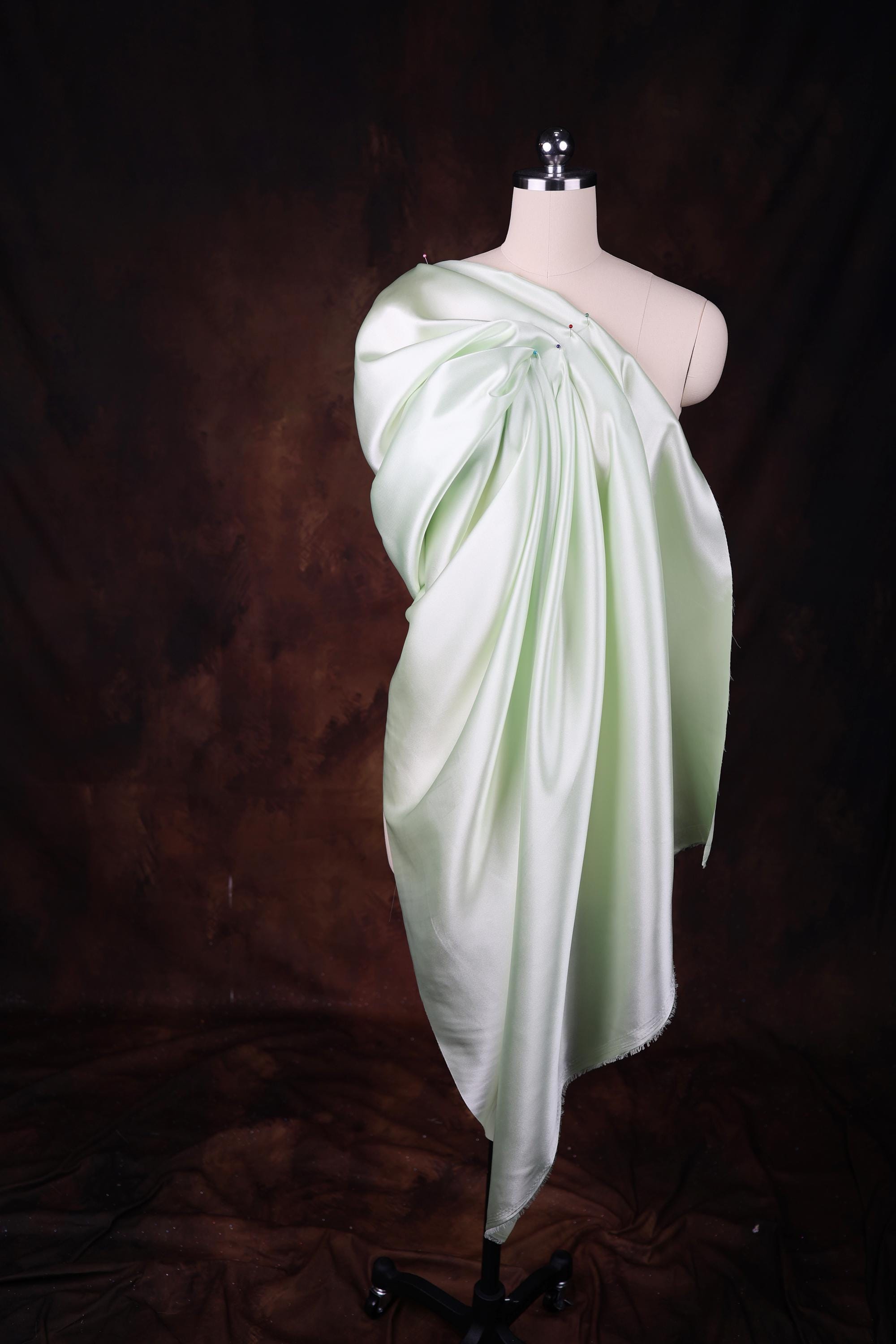 a mannequin wearing a white draped dress