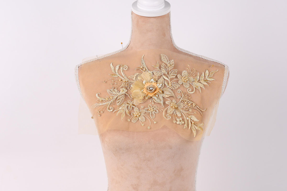 A mannequin with a delicate, intricate floral embroidery on its back.