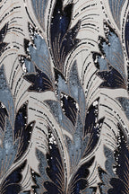 a close-up view of a fabric with a repeating pattern of blue and white leaves and flowers, adorned with sequins. The pattern is intricate and detailed, showcasing the craftsmanship and artistry involved in creating the fabric.