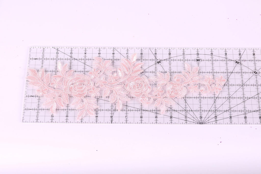 a clear ruler with a floral pattern of pink lace flowers placed on it.