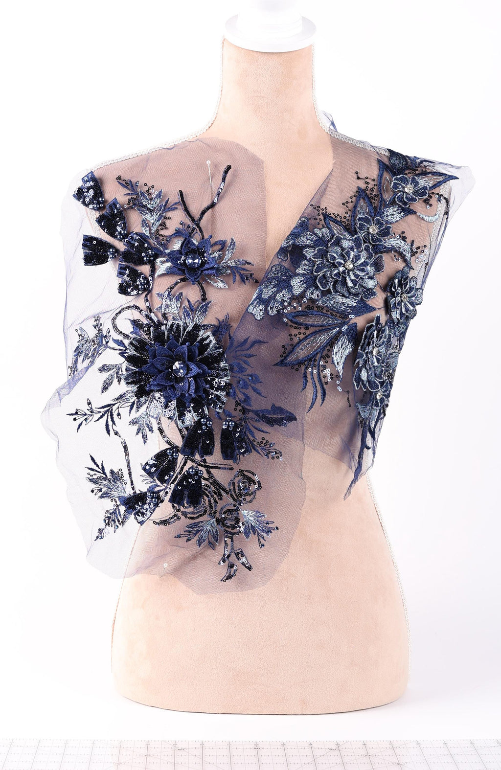 A mannequin wearing a dress with a sheer, floral-patterned fabric.