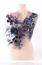 A mannequin wearing a dress with a sheer, floral-patterned fabric.