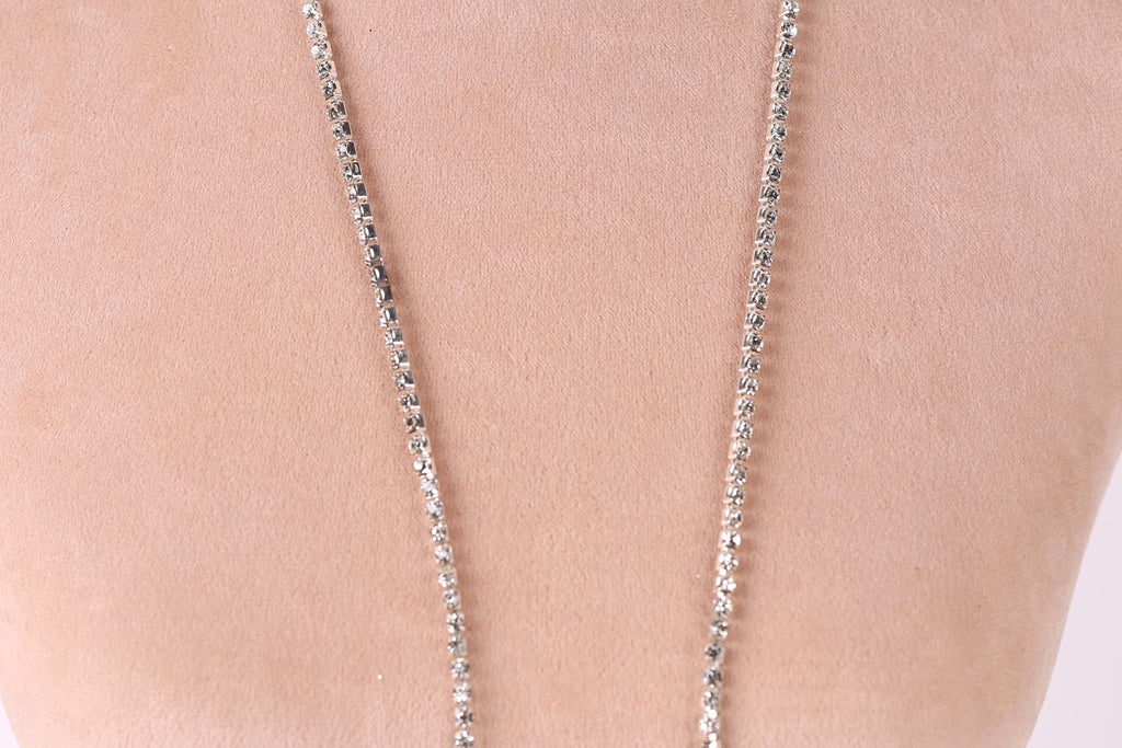 A close-up view of a necklace with a chain of small, clear, and shiny rhinestones or crystals.
