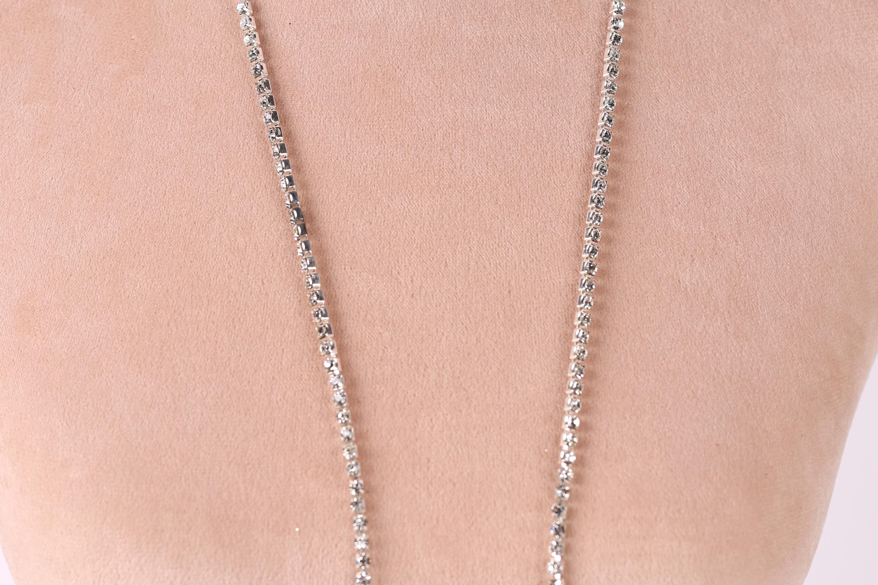 A close-up view of a necklace with a chain of small, clear, and shiny rhinestones or crystals.