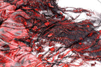 The image is a close-up of a fabric with a striking pattern of red and black sequins and lace. The fabric appears to be a sheer material, with a mix of black and red colors. The pattern is intricate and detailed, with the sequins and lace adding texture and depth to the fabric. The image does not contain any discernible objects or actions, and the focus is solely on the fabric and its design.