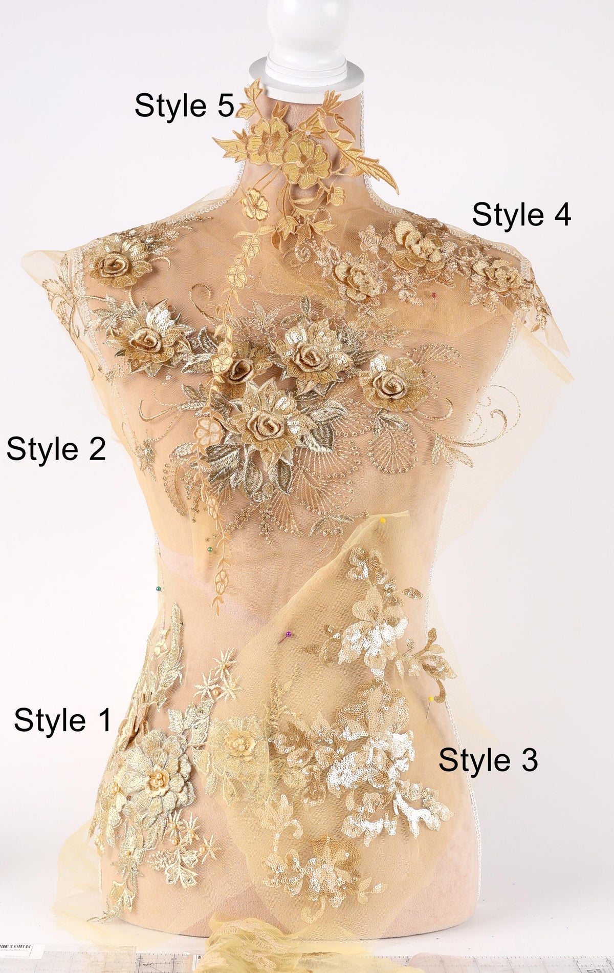 A mannequin with a beige dress adorned with intricate floral embroidery in various styles, including styles 5, 4, 2, 1, and 3.