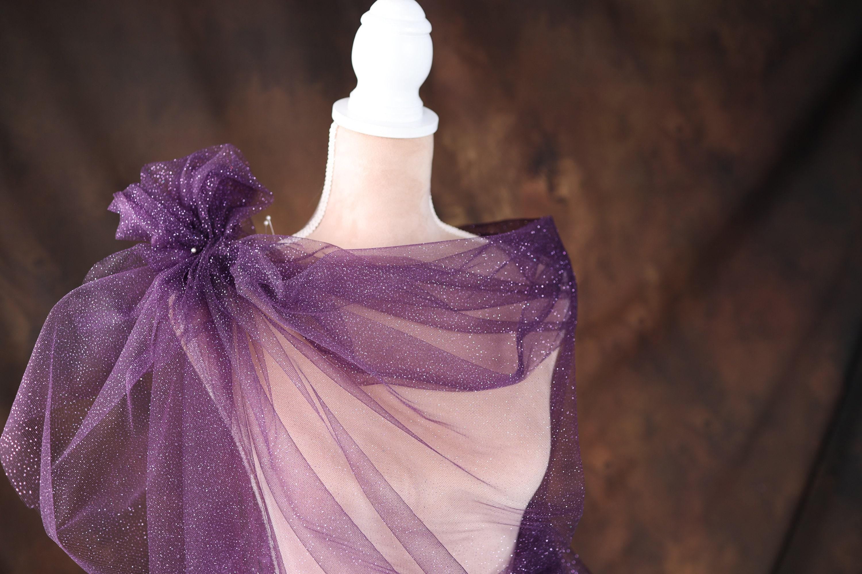 a mannequin dressed in a purple dress with a bow