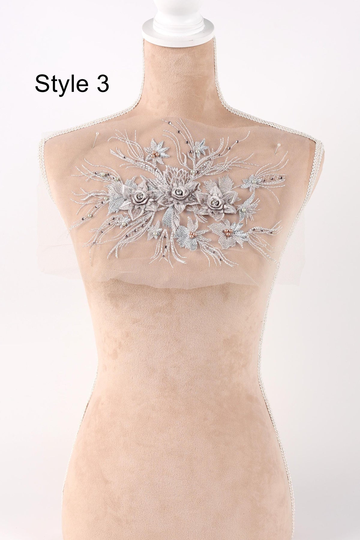 A mannequin with a decorative floral embroidery on its bust.