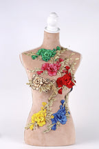 A mannequin with a beige body and colorful floral embroidery on its back.