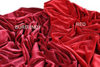 a close-up view of a crumpled red fabric, with the word "BURGENDY" and "RED" written on it, indicating the color of the fabric.