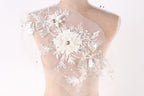 A mannequin wearing a white dress with intricate floral embroidery and sequins.
