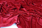 a close-up view of a crumpled red velvet fabric, with its folds and creases visible.