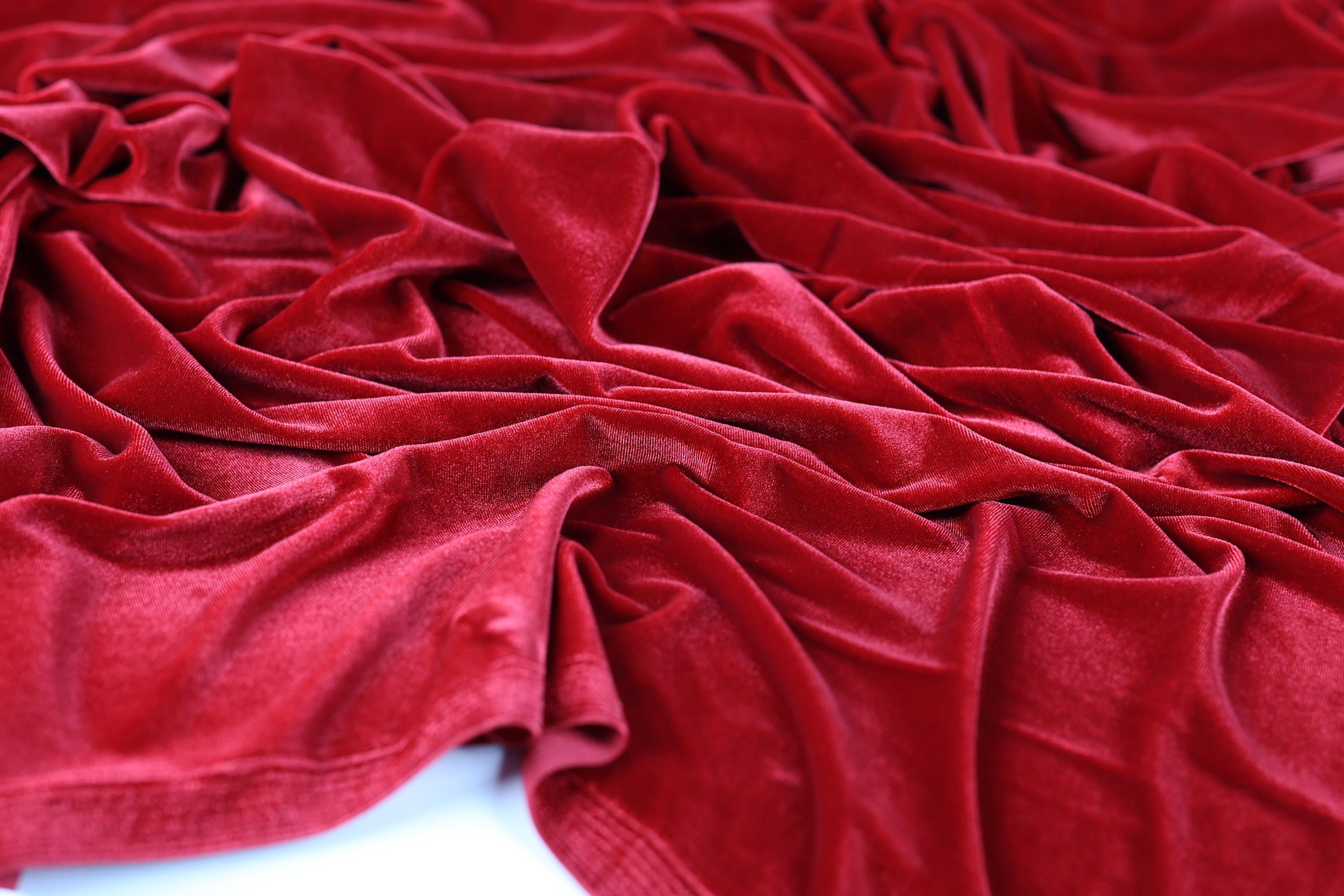 a close-up view of a crumpled red velvet fabric, with its folds and creases visible.