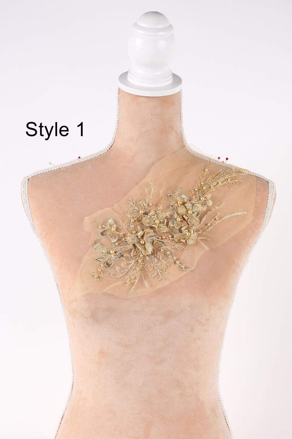 A mannequin with a decorative gold floral embellishment on its bust.