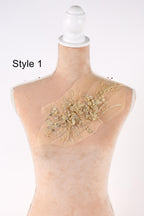 A mannequin with a decorative gold floral embellishment on its bust.
