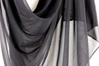 a close-up view of a black, sheer fabric, possibly a scarf or garment, with a textured and wrinkled appearance.