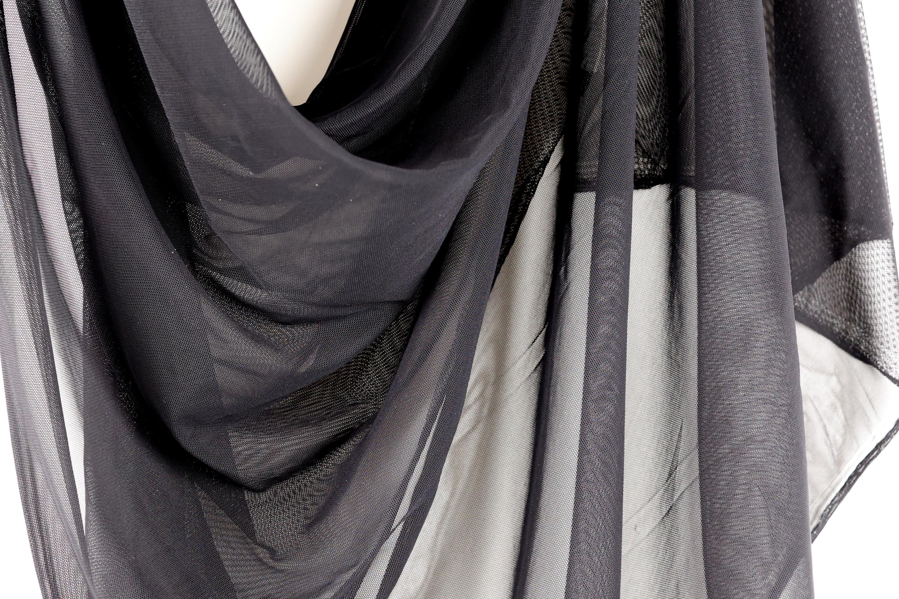 a close-up view of a black, sheer fabric, possibly a scarf or garment, with a textured and wrinkled appearance.