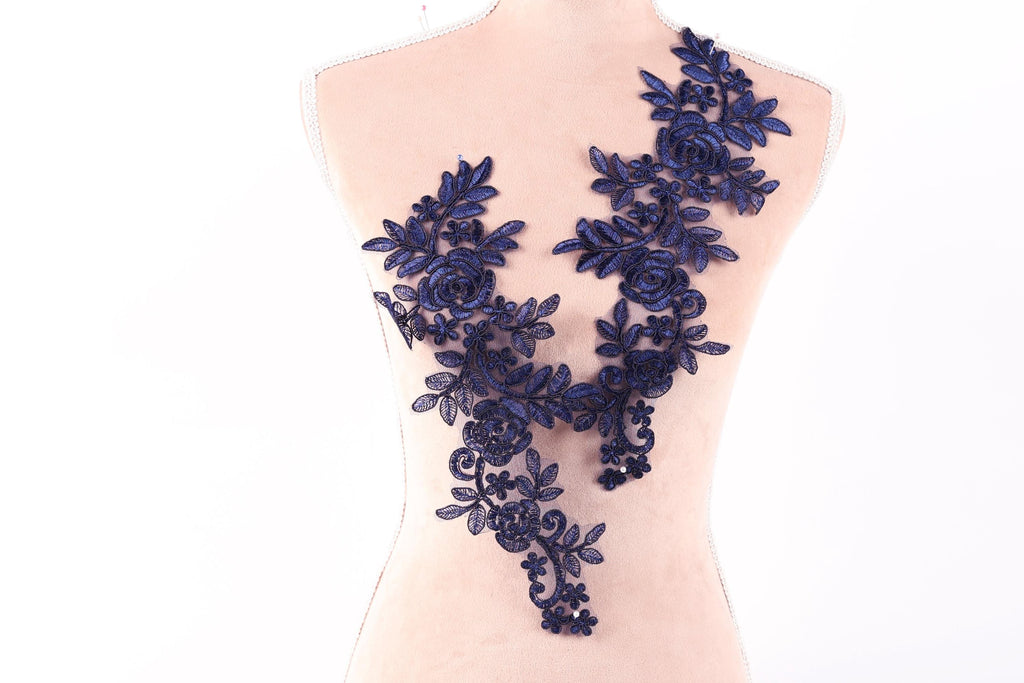 A mannequin torso with a decorative blue floral lace overlay.