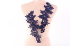 A mannequin torso with a decorative blue floral lace overlay.