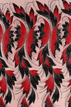 a repeating pattern of red and black flowers with long, flowing petals against a light pink background.