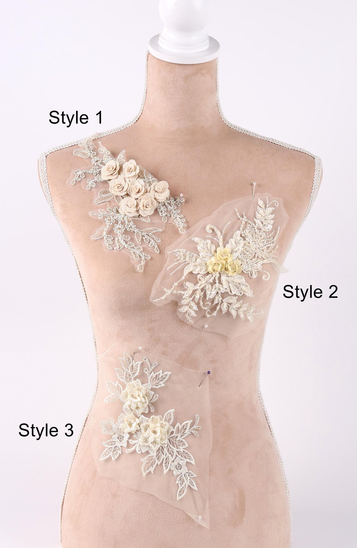 A mannequin with three different styles of lace or floral embellishments displayed on its bust.