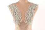 a mannequin torso wearing a decorative piece of clothing with intricate beaded and lace details.
