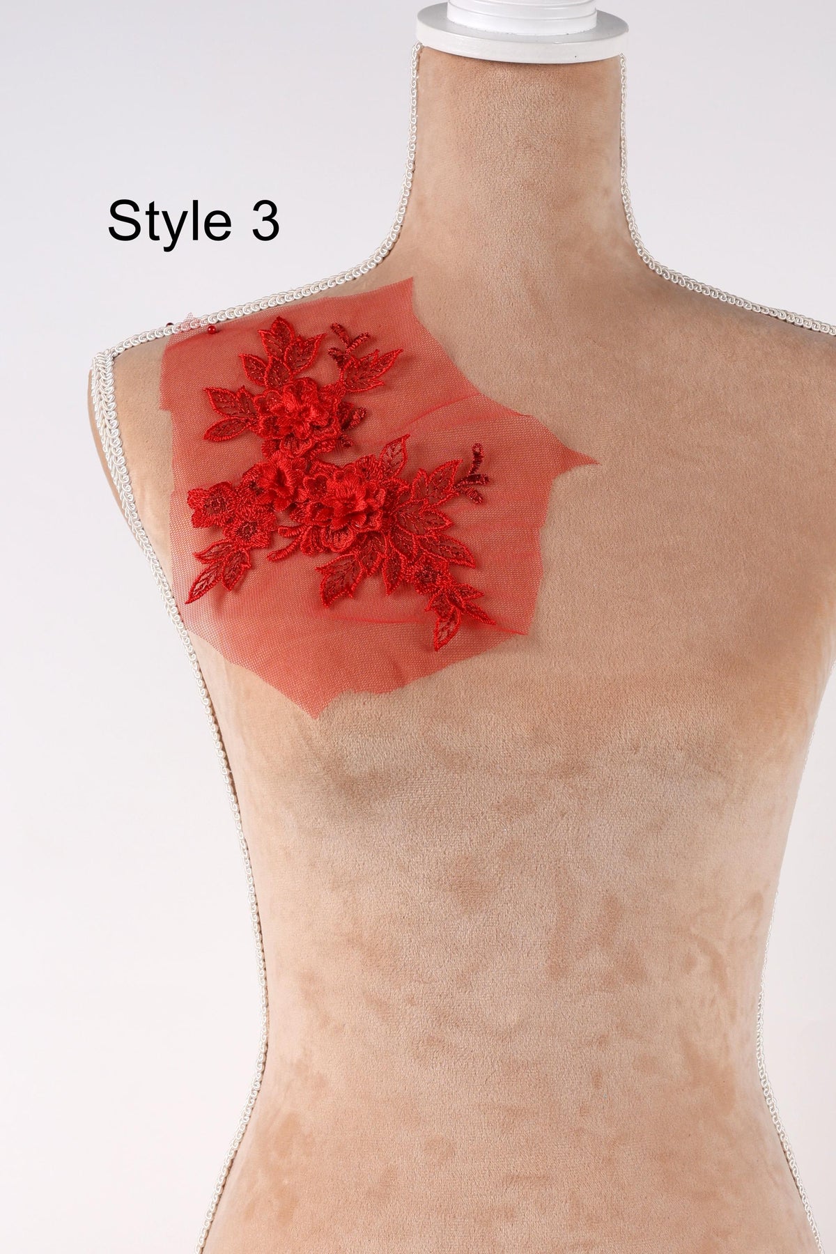 A mannequin with a red floral design on its shoulder.