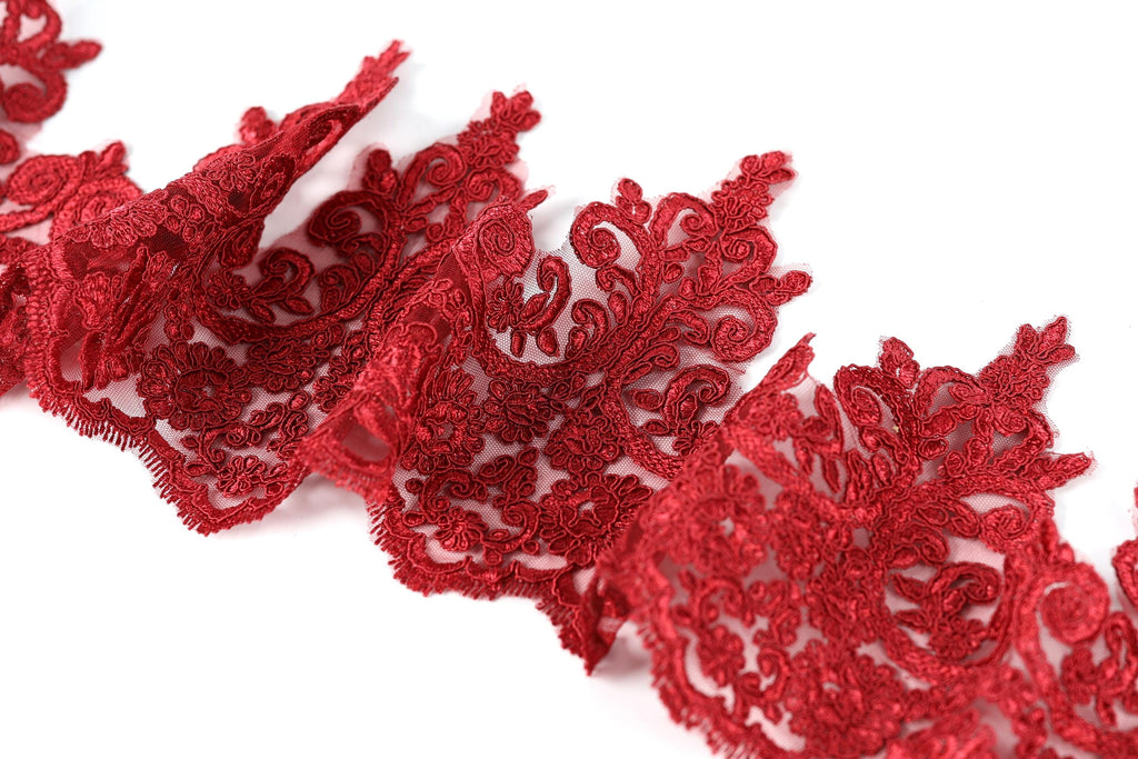 a close-up view of a piece of red lace with intricate floral patterns.