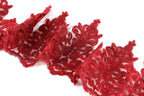 a close-up view of a piece of red lace with intricate floral patterns.