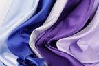 a close-up view of a variety of colorful fabrics, including blue, purple, and white, arranged in a visually appealing manner.