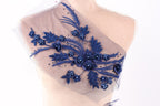 A mannequin torso with a decorative fabric overlay featuring blue floral and leaf patterns.