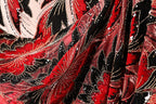 The image is a close-up of a fabric with a floral pattern in red, black, and white. The fabric appears to be made of sequin material, with a shiny, glittery appearance.