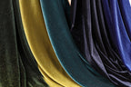 a close-up view of several colorful velvet fabric swatches, with a mix of gold, blue, and black hues.