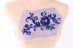 a mannequin torso with a piece of fabric featuring a blue floral design.
