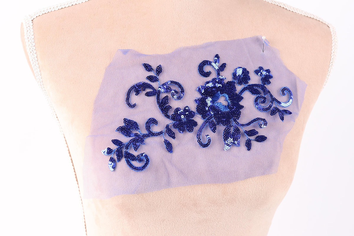 a mannequin torso with a piece of fabric featuring a blue floral design.