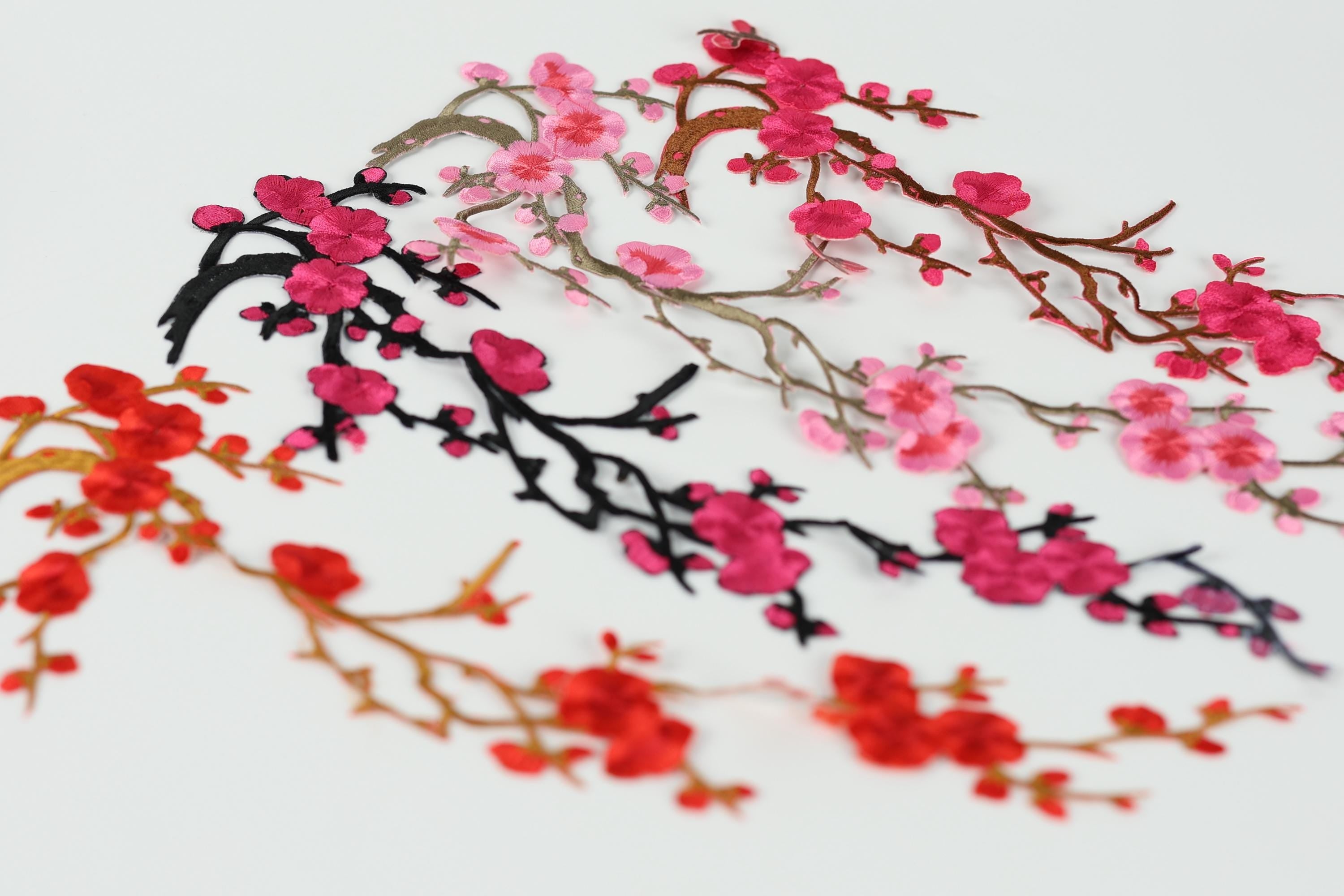 a variety of colorful floral designs, including pink and red flowers, as well as black and red branches, arranged in a visually appealing manner.