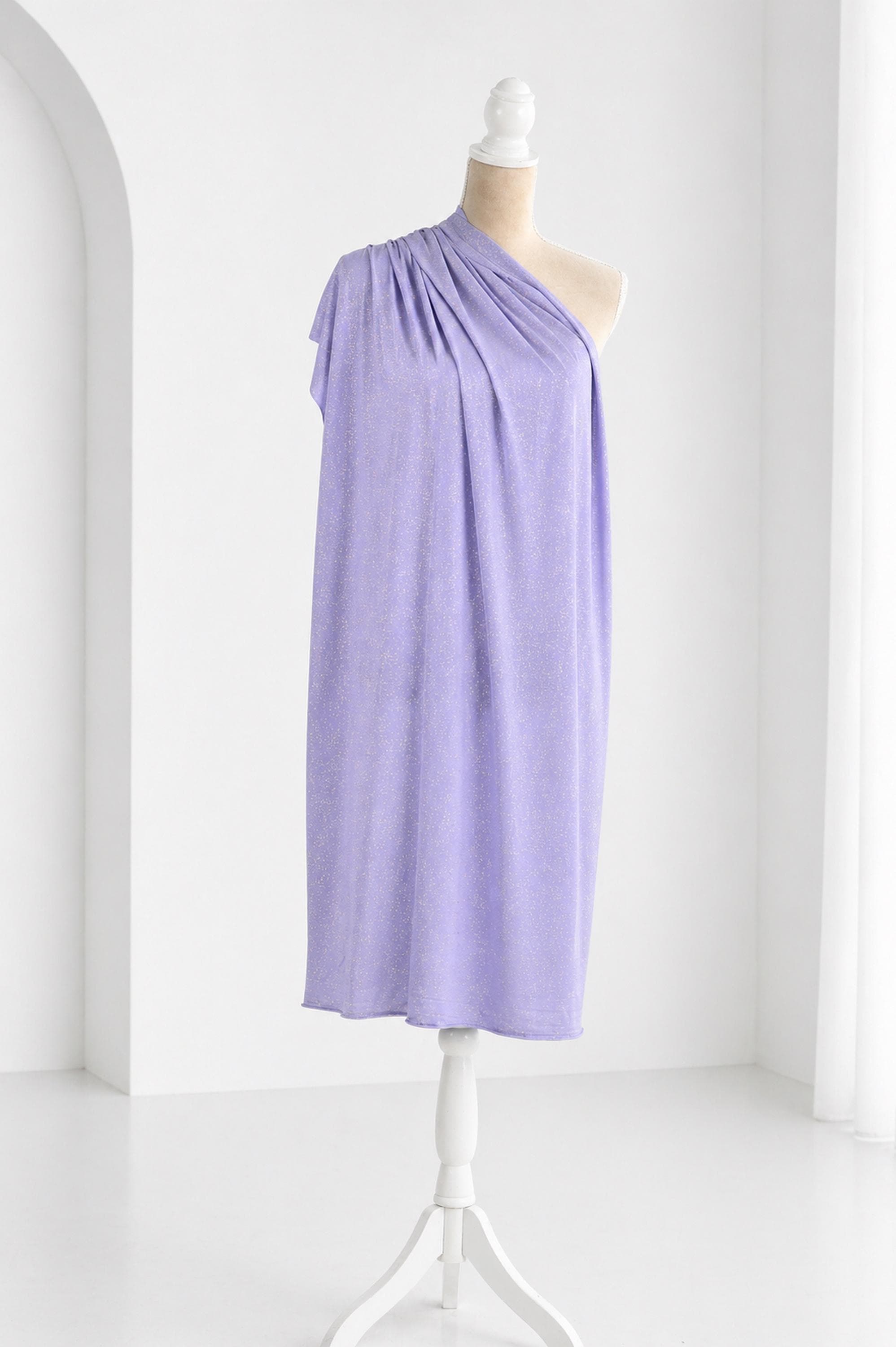 A mannequin wearing a purple one-shoulder dress stands on a white stand against a white background.