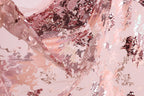 The image is a close-up of a fabric with a pink and red floral pattern, featuring sequins and lace-like textures.