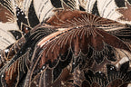 The image is a close-up of a fabric with a floral pattern, featuring a mix of brown, black, and gold colors. The fabric appears to be made of sequin material, with a detailed and intricate design.