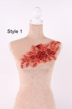 A mannequin with a red floral embroidered patch on its chest.