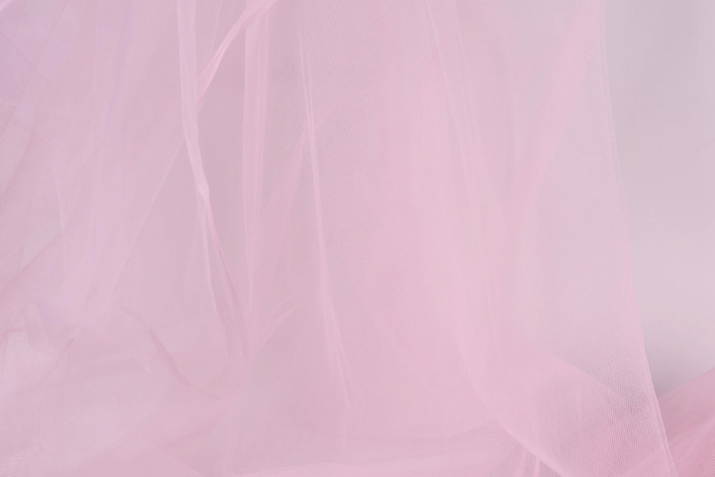 The image is a close-up of a soft, light pink fabric, possibly a sheer or sheer-like material. The fabric appears to be delicate and delicate, with a smooth texture that is visually appealing.