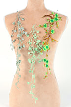 a mannequin torso adorned with a variety of green and white floral and leaf-like designs, creating a visually striking and nature-inspired appearance.