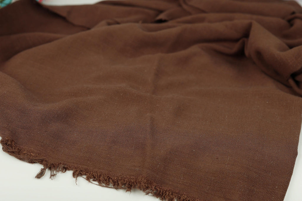 A brown fabric with frayed edges is shown in the image.