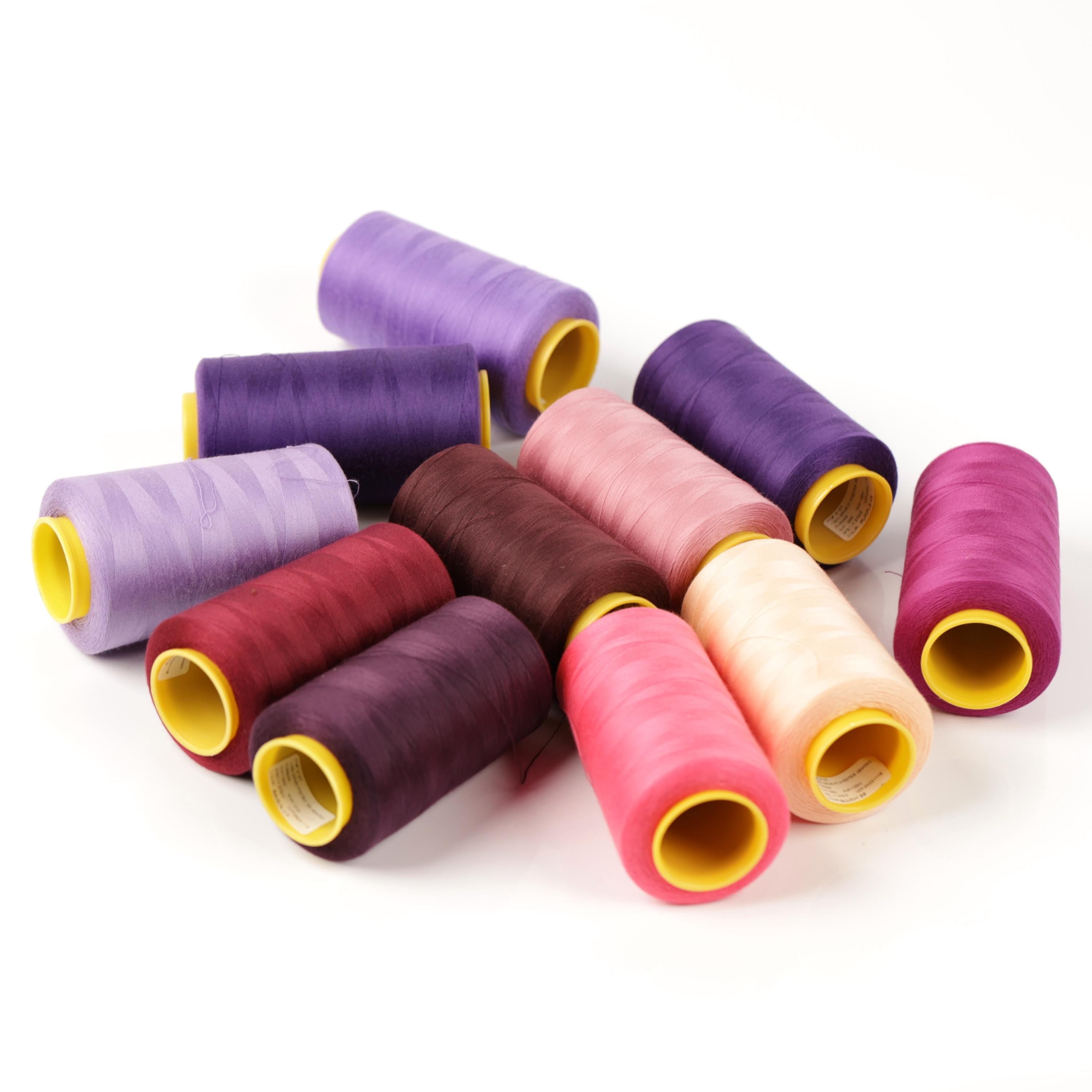 a collection of colorful spools of thread in various shades, including purple, pink, and maroon, arranged on a white background.