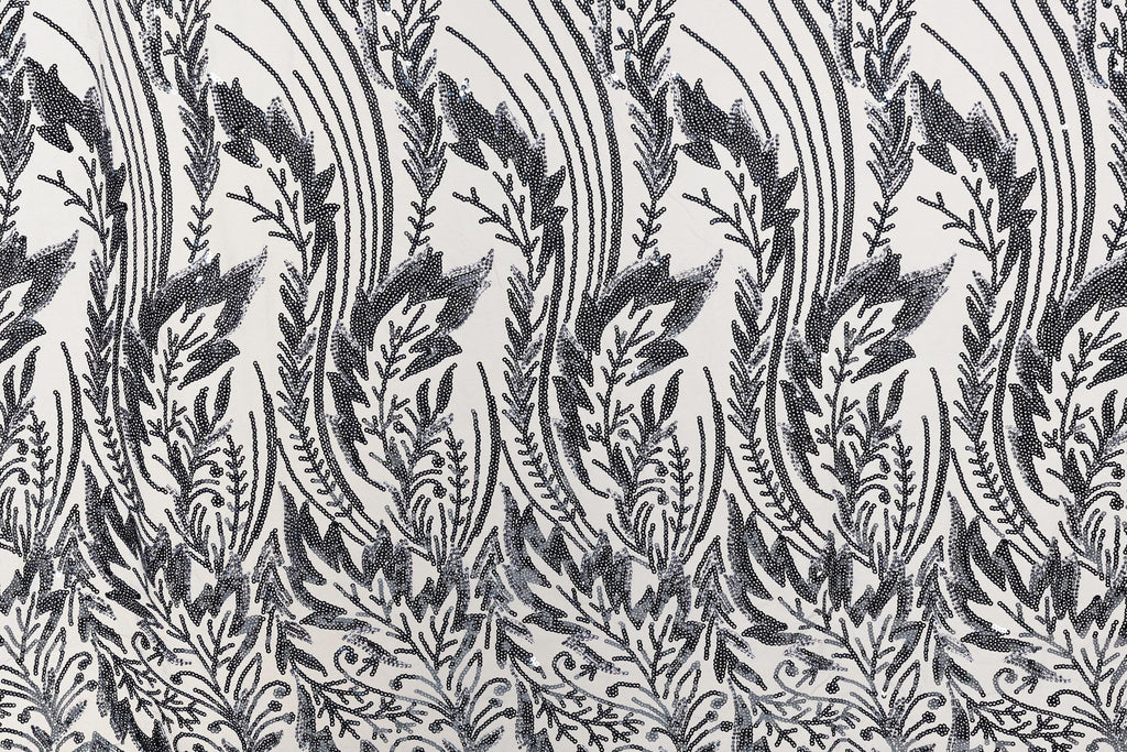 a repeating pattern of black and white floral designs on a fabric surface.