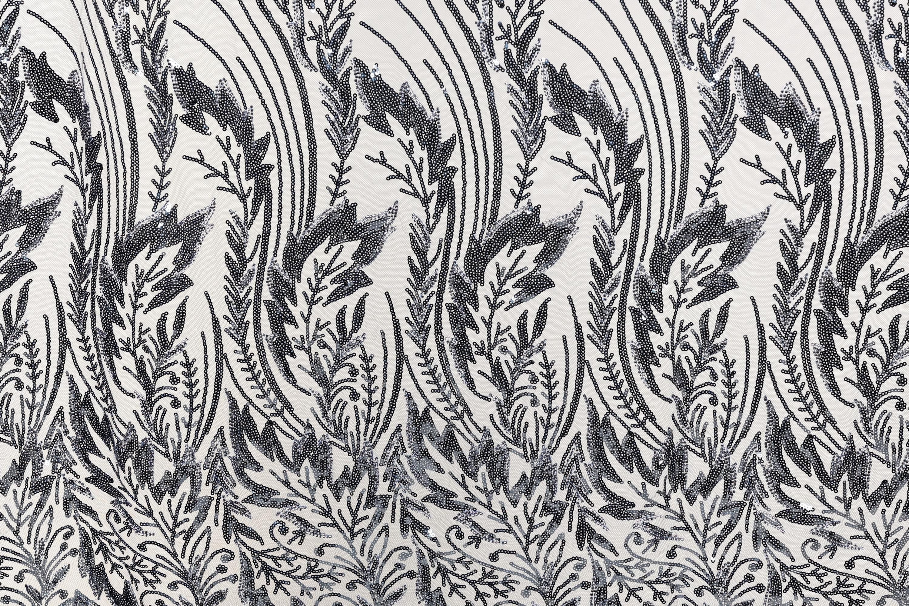 a repeating pattern of black and white floral designs on a fabric surface.