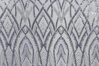 a repeating pattern of diamond-shaped sequins in shades of blue and gray, creating a visually striking and intricate design.