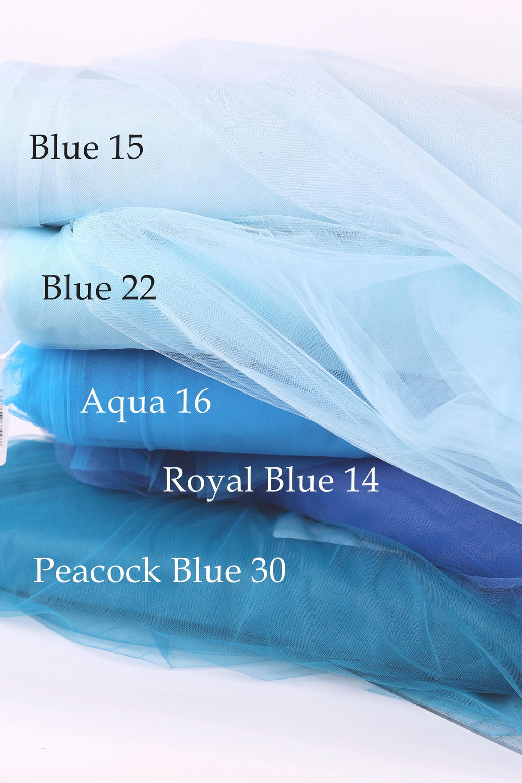 a stack of different colored tulle fabric, including Blue 15, Blue 22, Aqua 16, Royal Blue 14, and Peacock Blue 30, arranged in a visually appealing manner.