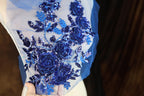 a woman wearing a blue dress with blue flowers on it